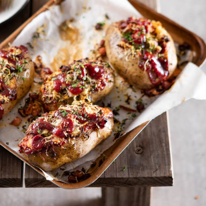Papas asadas rellenas con cebolla de verdeo, queso crema, panceta crocante y kétchup