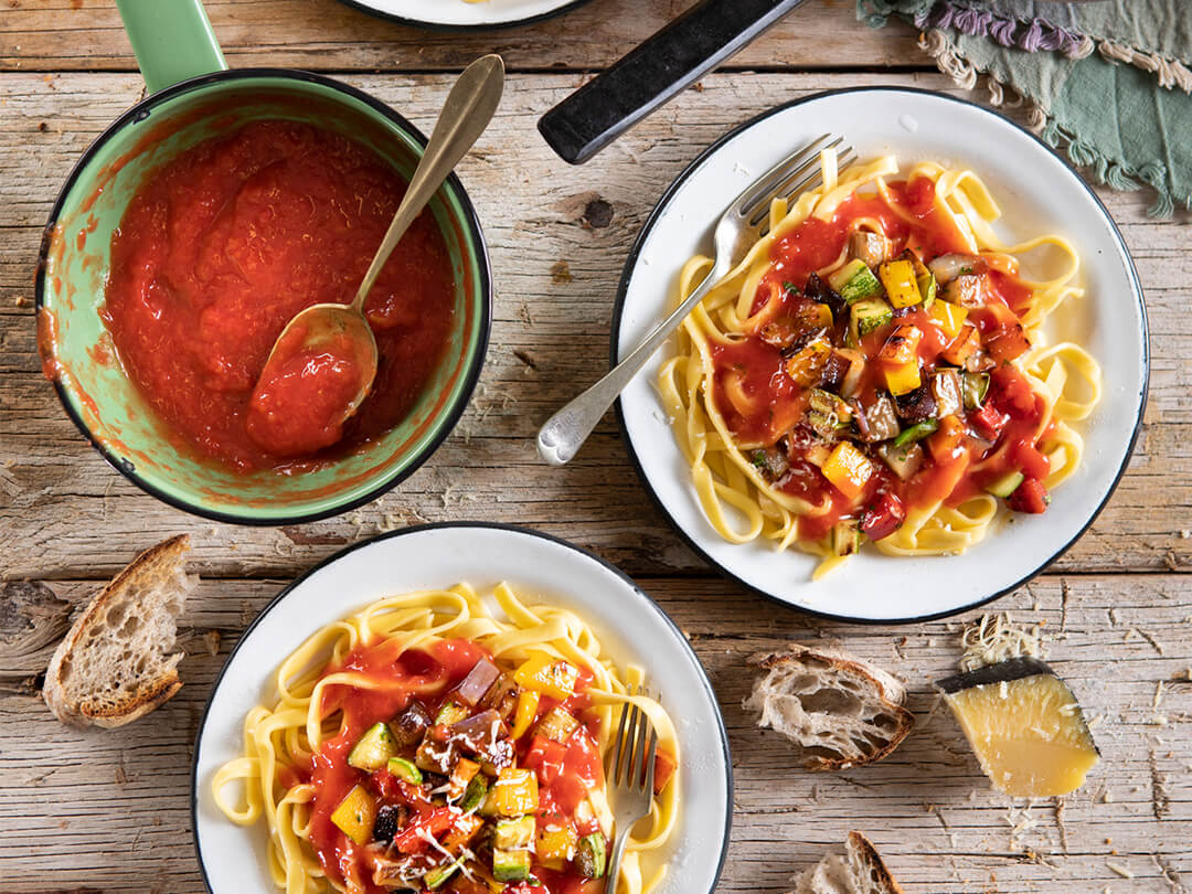 Fideos con puré de tomates y verduras salteadas