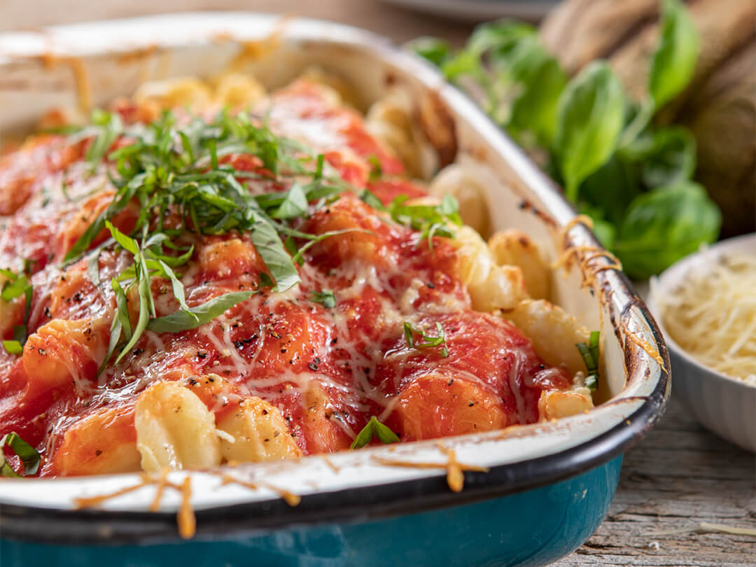 Ñoquis de papa con salsa de tomates y hojas frescas de albahaca