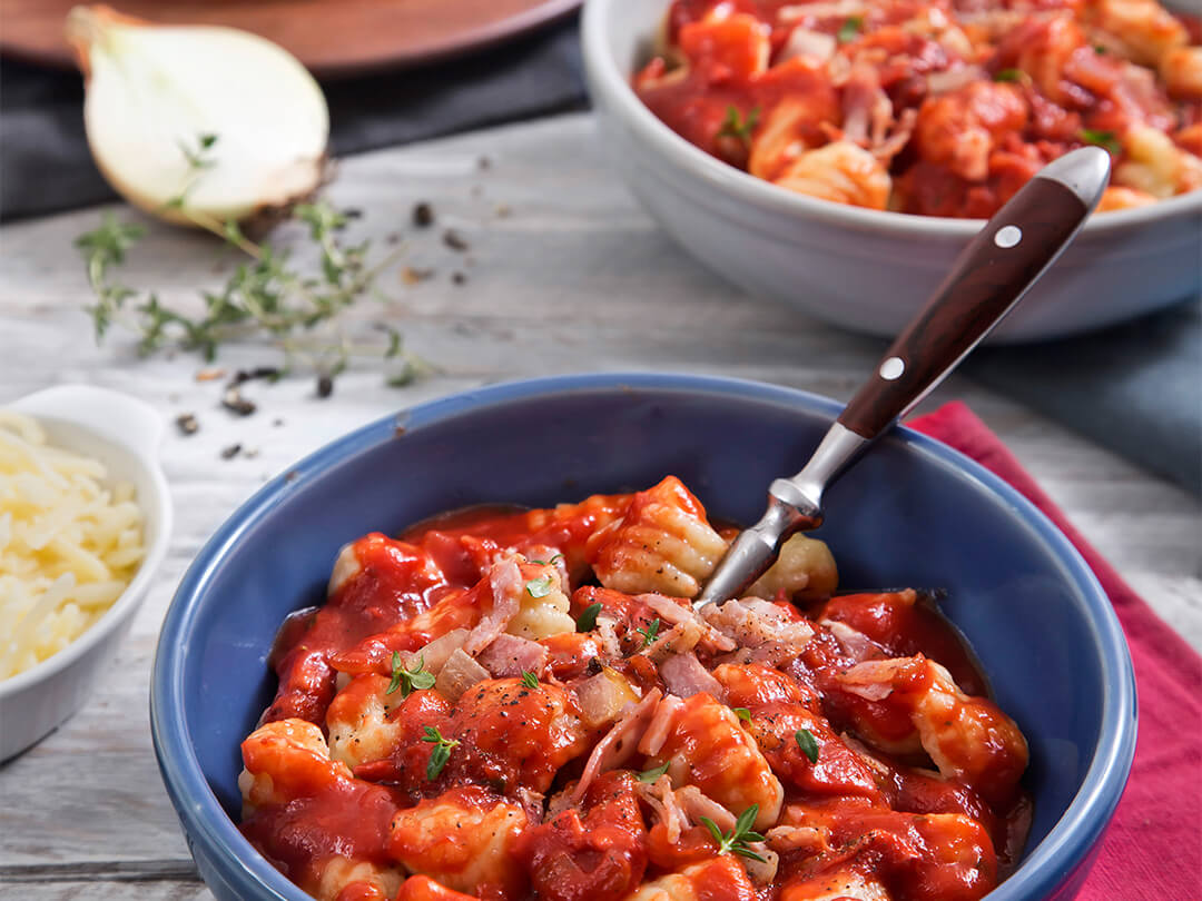 Ñoquis de papa con Parmesano, salsa de tomate, cebolla y panceta