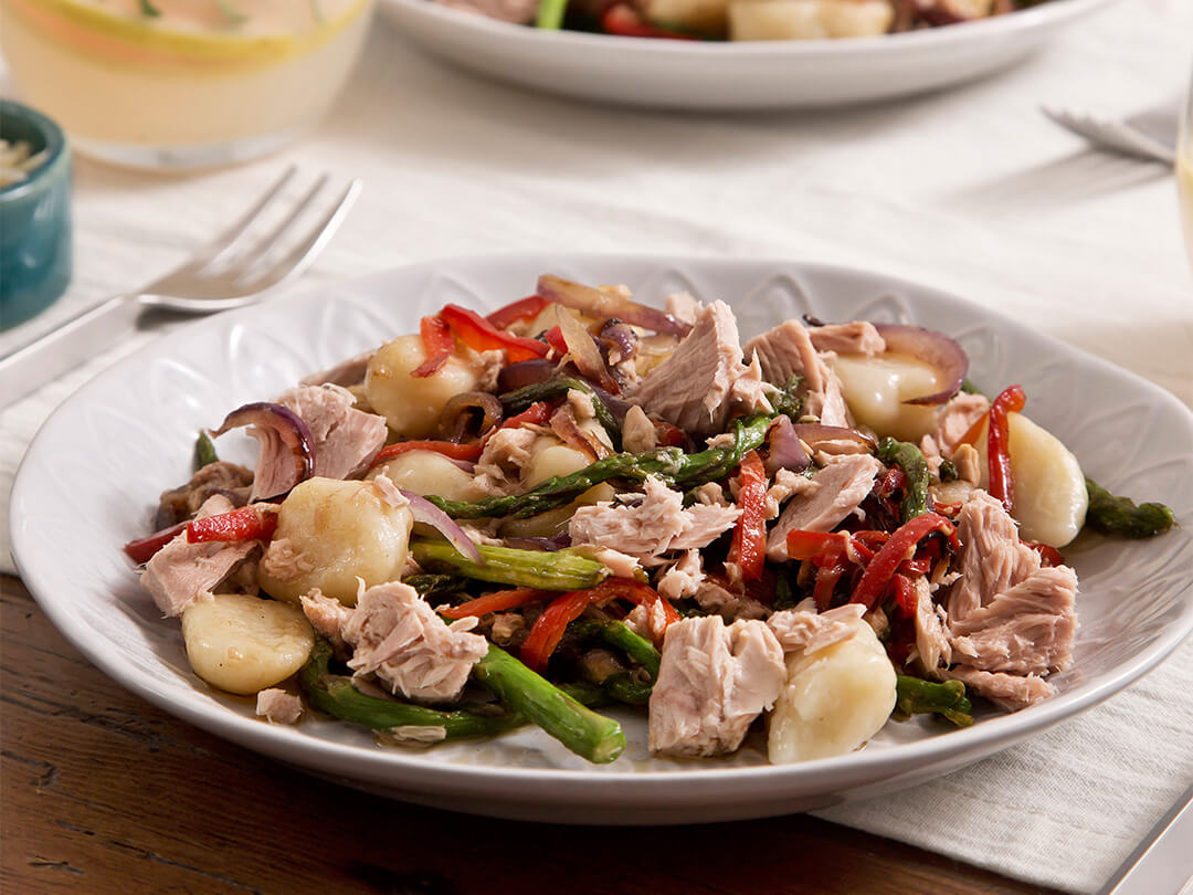 Ñoquis de papa con atún, espárragos, morrones, cebolla morada y aceite de oliva