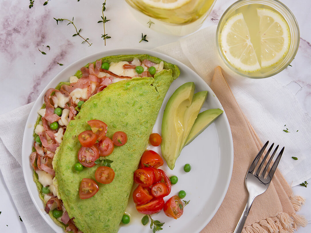 Omelette de huevo y arvejas relleno con tomates cherry, jamón y queso