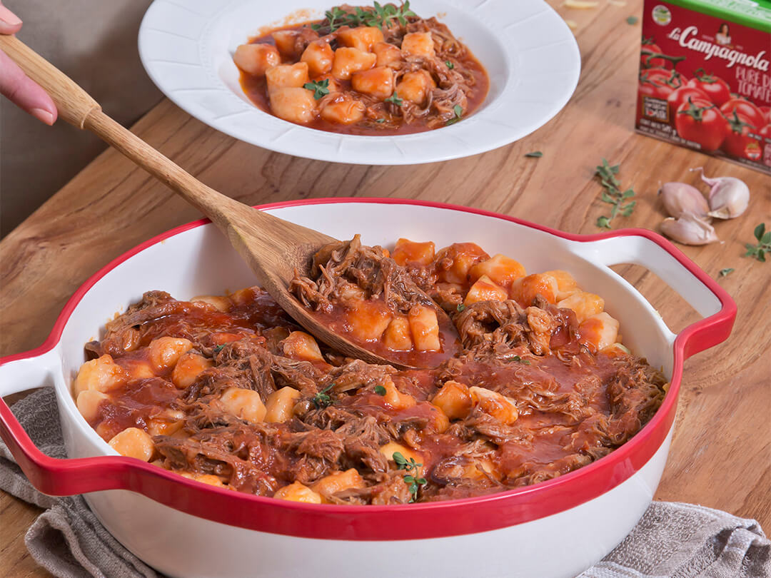 Ñoquis de calabaza en salsa con carne desmechada