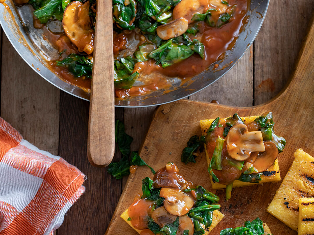 Cuadraditos de polenta con espinaca, ajo y hongos