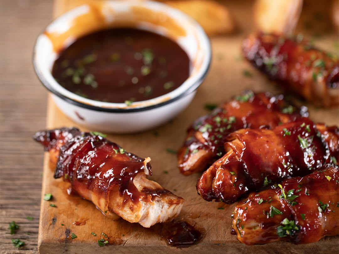 Pechuguitas de pollo envueltas en panceta, doradas con barbacoa y papas fritas