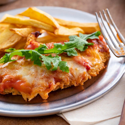 Milanesitas de pollo a la napolitana con salsa portuguesa y rúcula