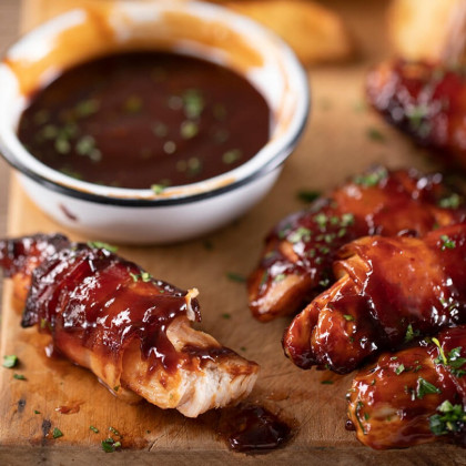 Pechuguitas de pollo envueltas en panceta, doradas con barbacoa y papas fritas
